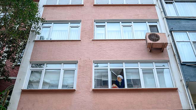 سيفيم أوزكان ، امرأة تركية تبلغ من العمر 85 عامًا تعيش بمفردها في منزلها ، تنتظر مع سلتها لجارتها